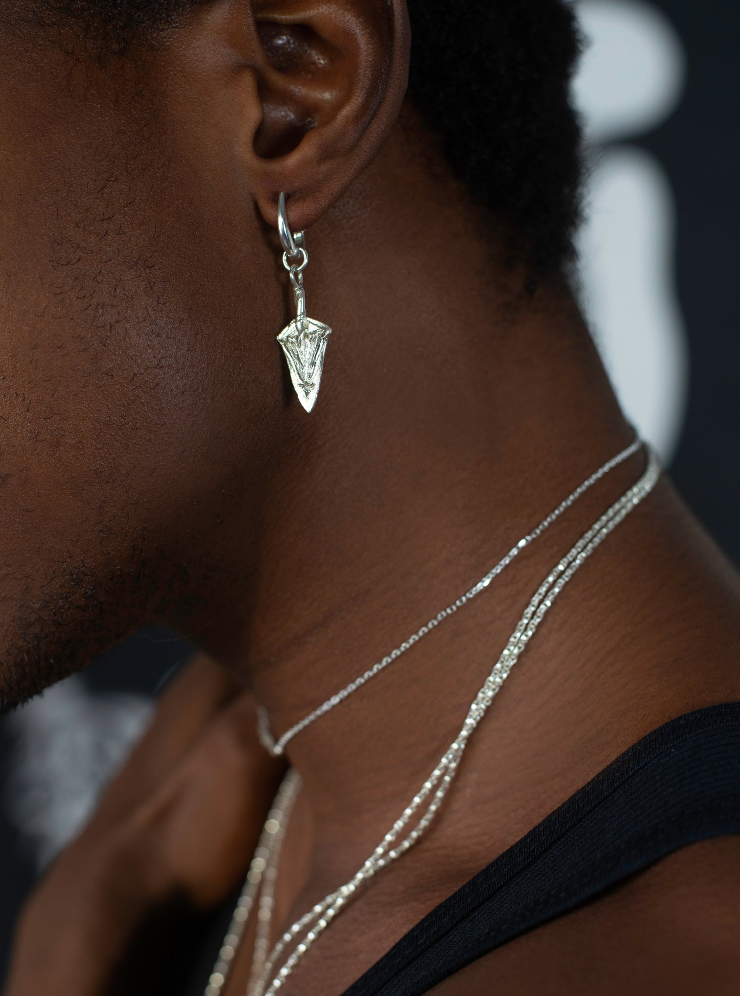 Close up detail of model wearing sterling silver spear shaped earring