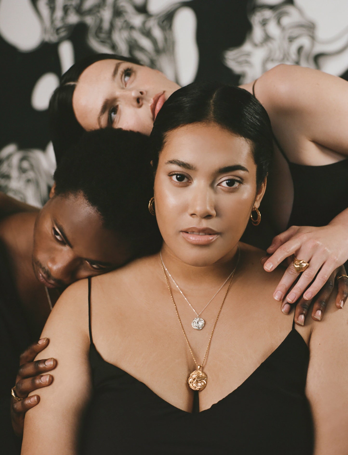 Model wearing golden hoop earrings and layered necklaces