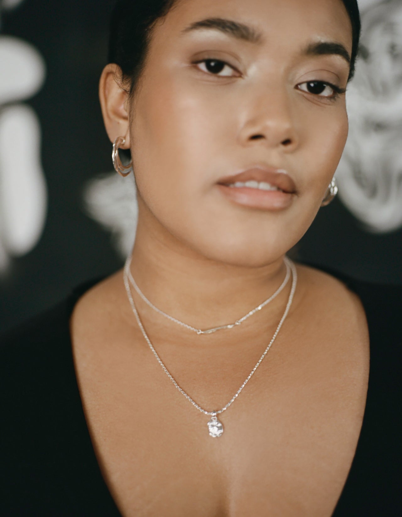 Model wearing sterling silver necklace with stone like pendant