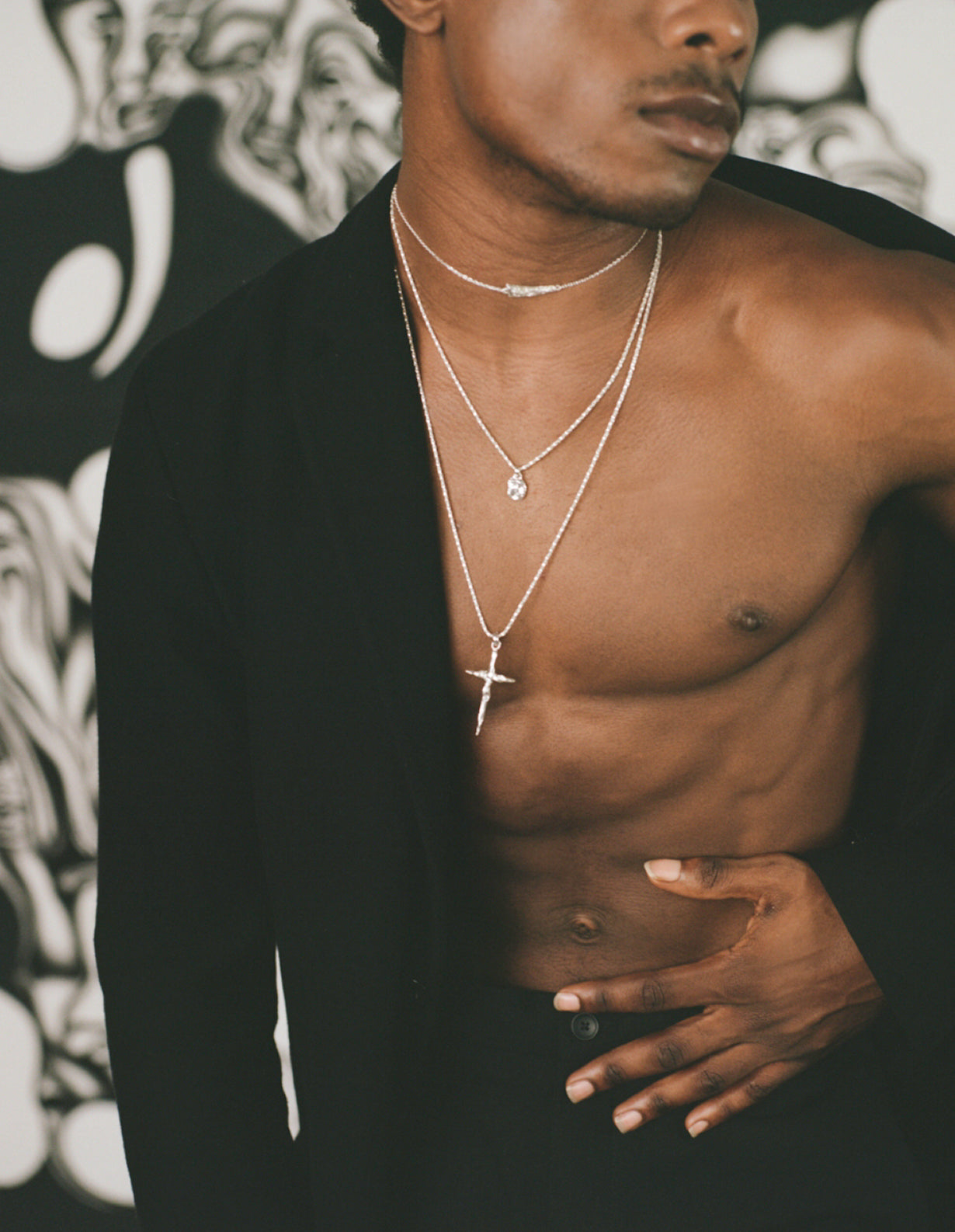 Model wearing black jacket with sterling silver crucifix necklace