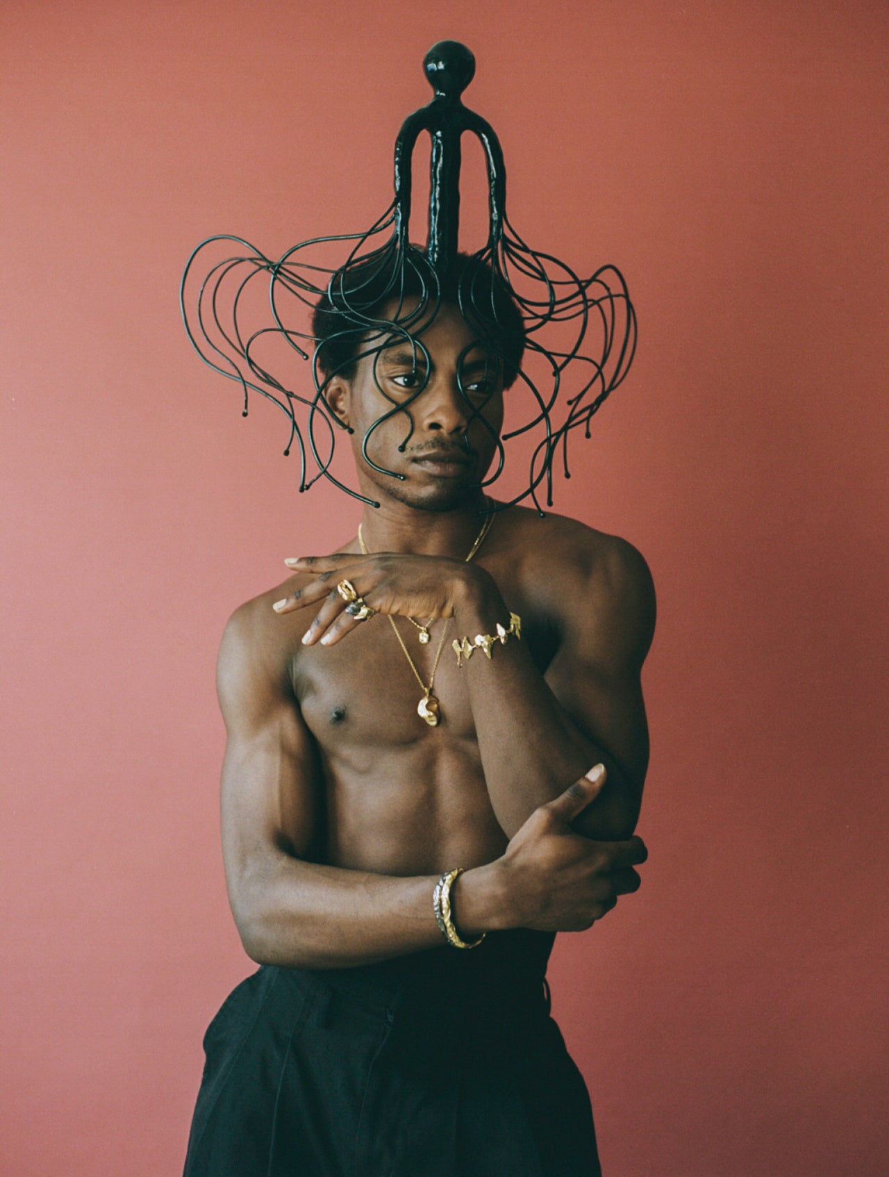 Model wearing black headpiece with gold handcrafted jewellery