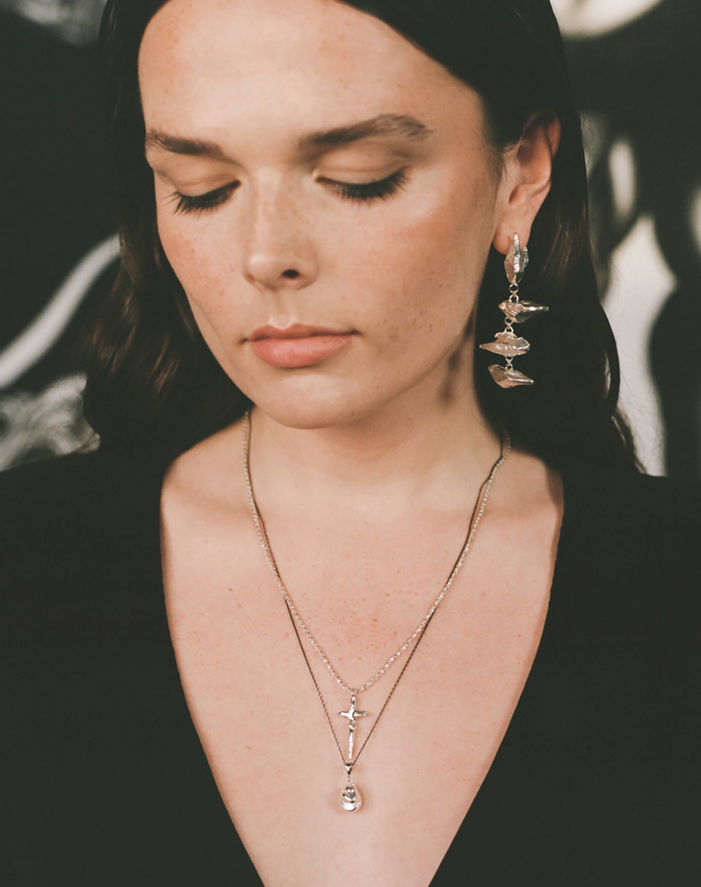 Model wearing crucifix necklace with statement Richard Murphy earring