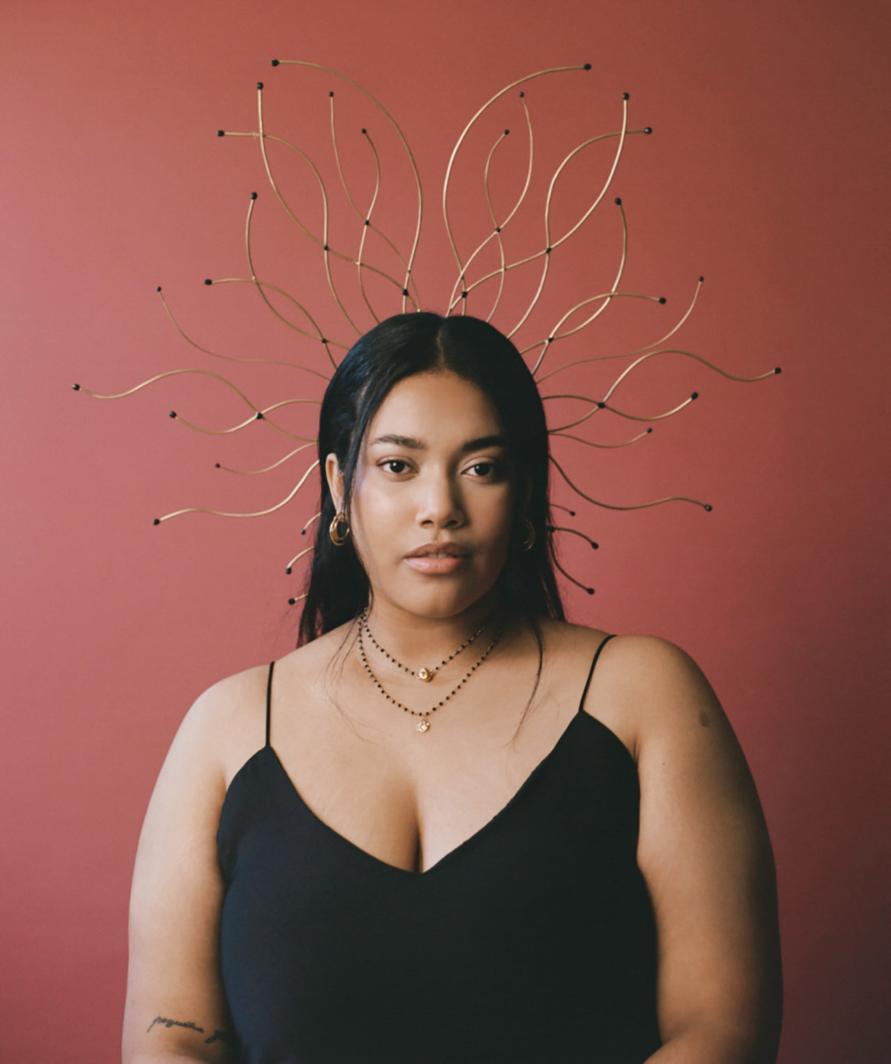 Model wearing headpiece with black beads and black beaded chain necklace