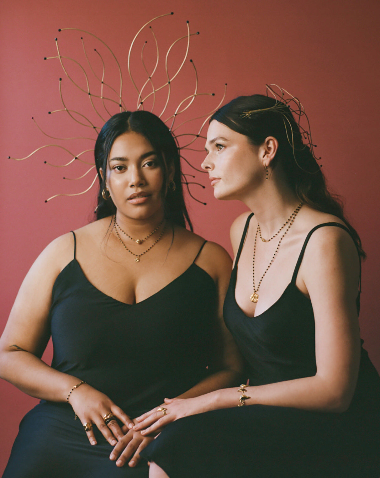 Models wearing black beaded jewellery and delicate handmade headpieces