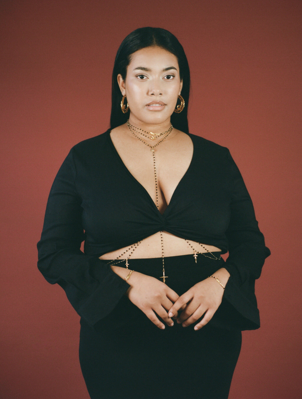 Model wearing body chain with large hoop earrings