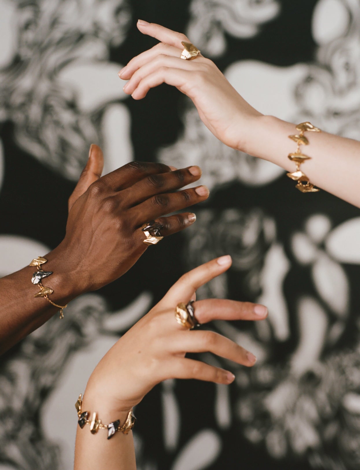 Model's hands wearing handcrafted Irish rings and bracelets