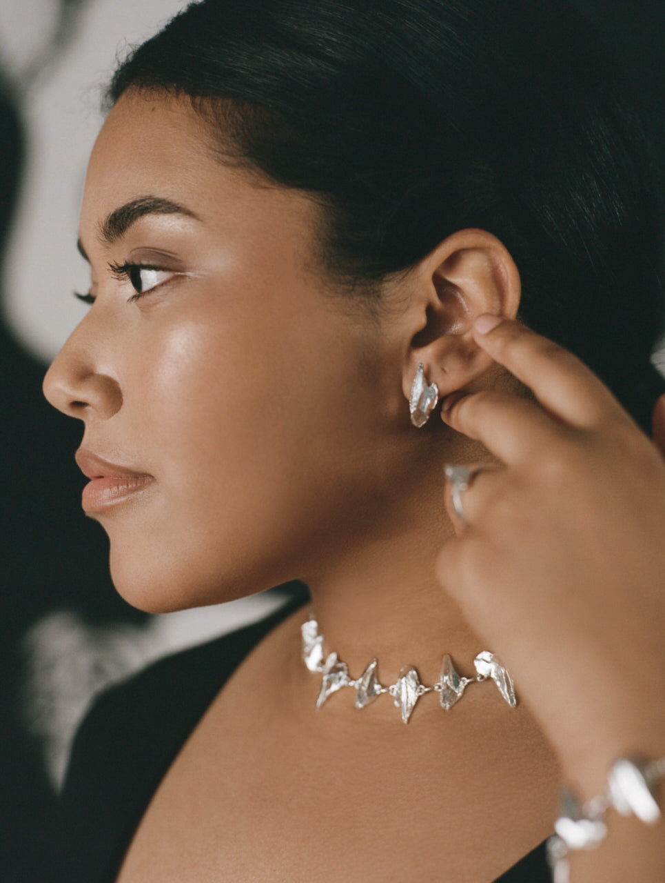Model wearing stud earrings and punk style necklace in sterling silver