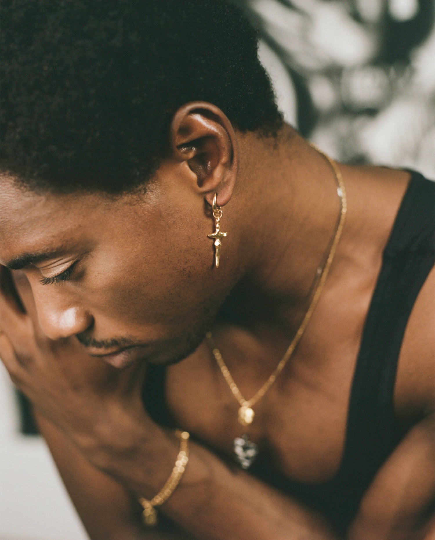 Model wearing gold crucifix hoop earring